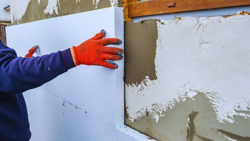 Un enduiseur à Coutras pose un bloc de polystyrène pour isoler un mur extérieur avec une aide isolation extérieur en 2023