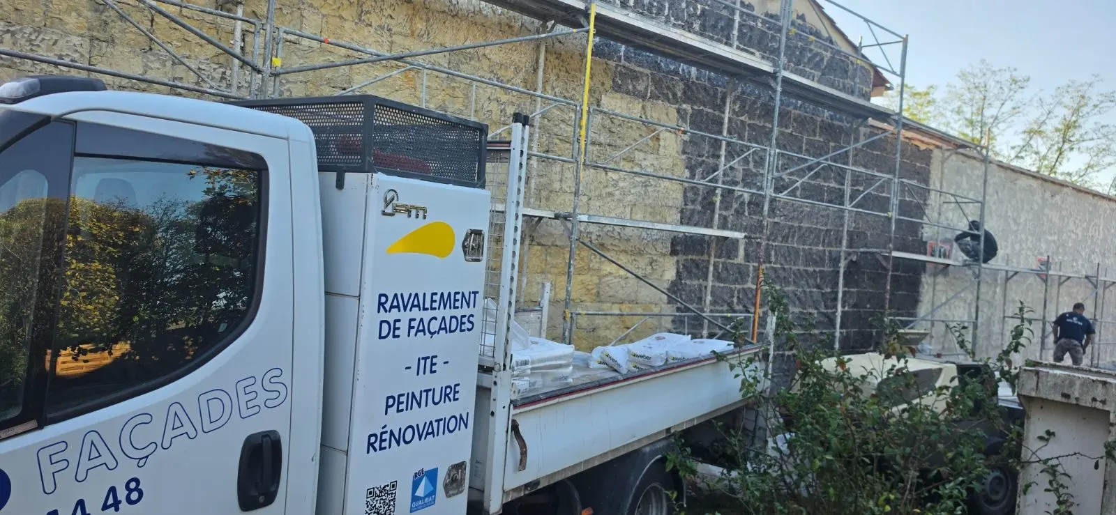 Échafaudage et camion JDPO Façades devant une façade en cours d'enduit à la chaux à Coutras
