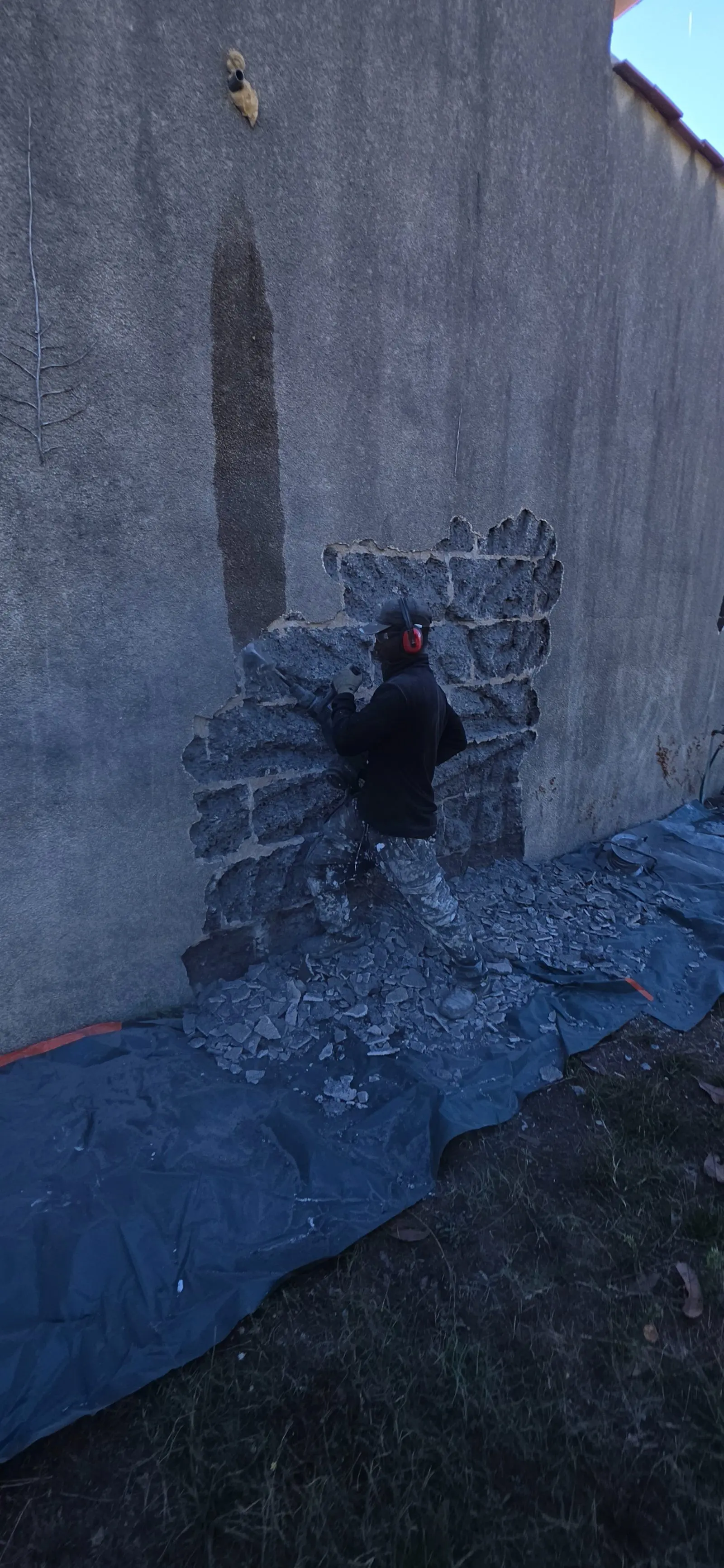Picage de l'ancien enduit ciment sur un mur de maison ancienne à Coutras
