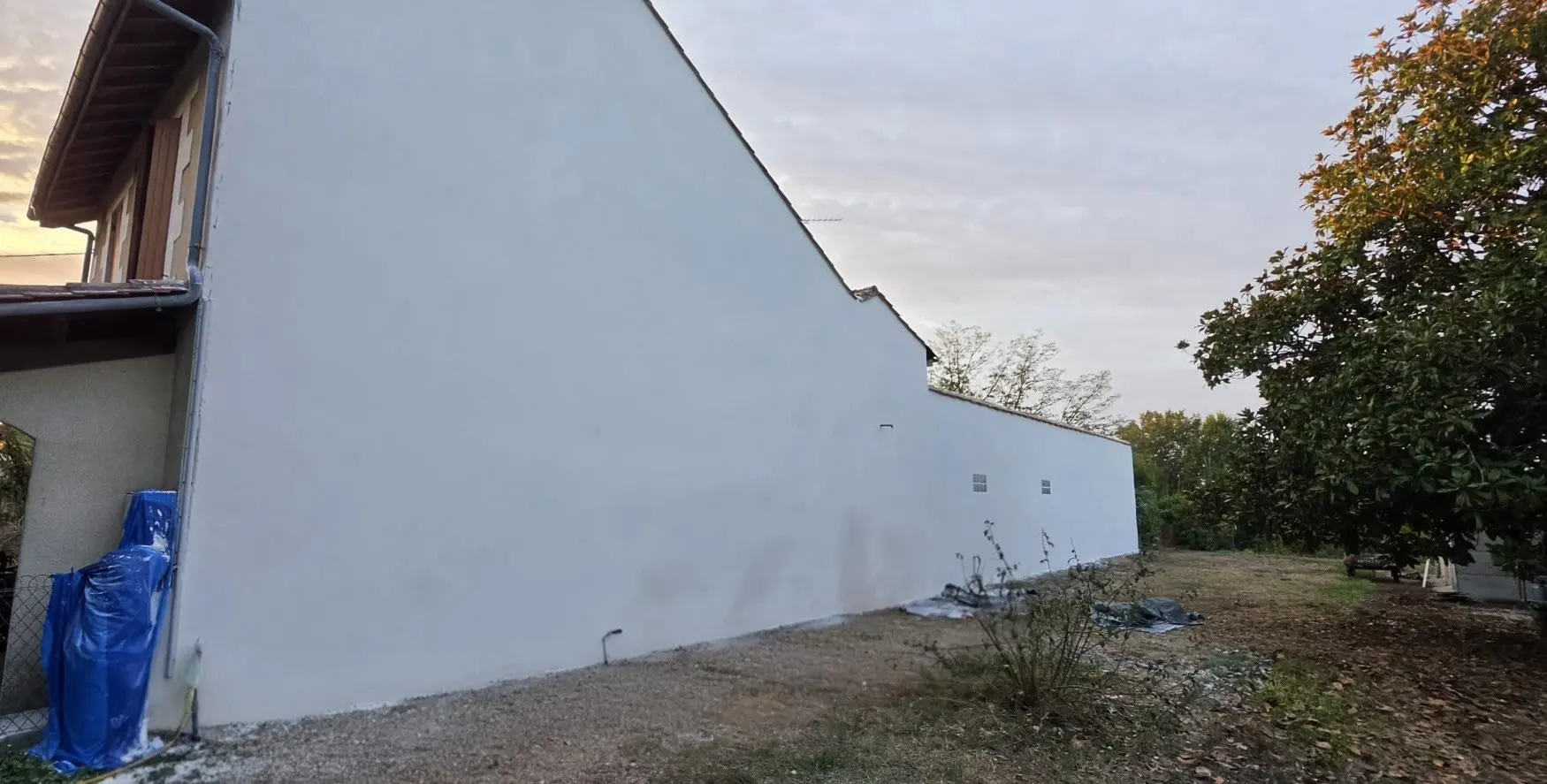 Pignon et long mur de maison ancienne à Coutras après l'enduit de finition gratté fin à la chaux