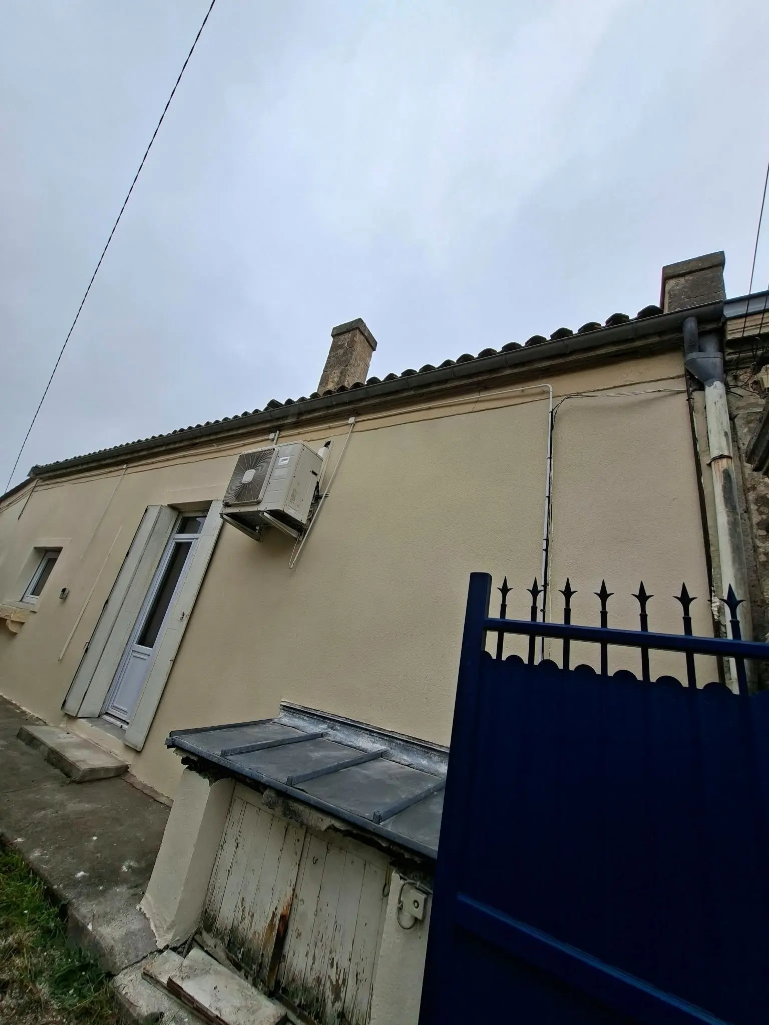 Façade enduite à la chaux avec menuiseries et volets après travaux à Talence