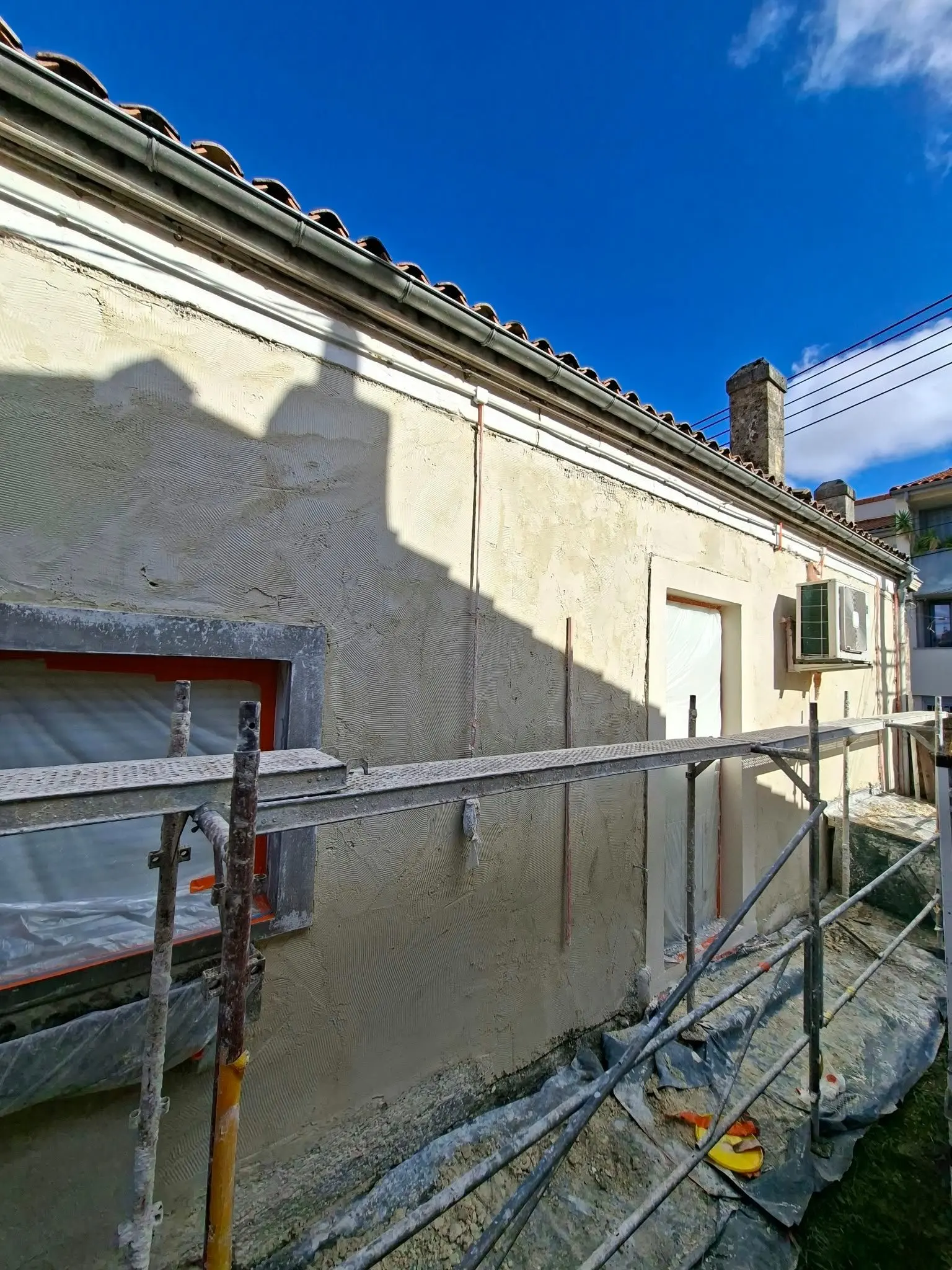 Sous-enduit à la chaux avec trame de rénovation en cours d'application à Talence