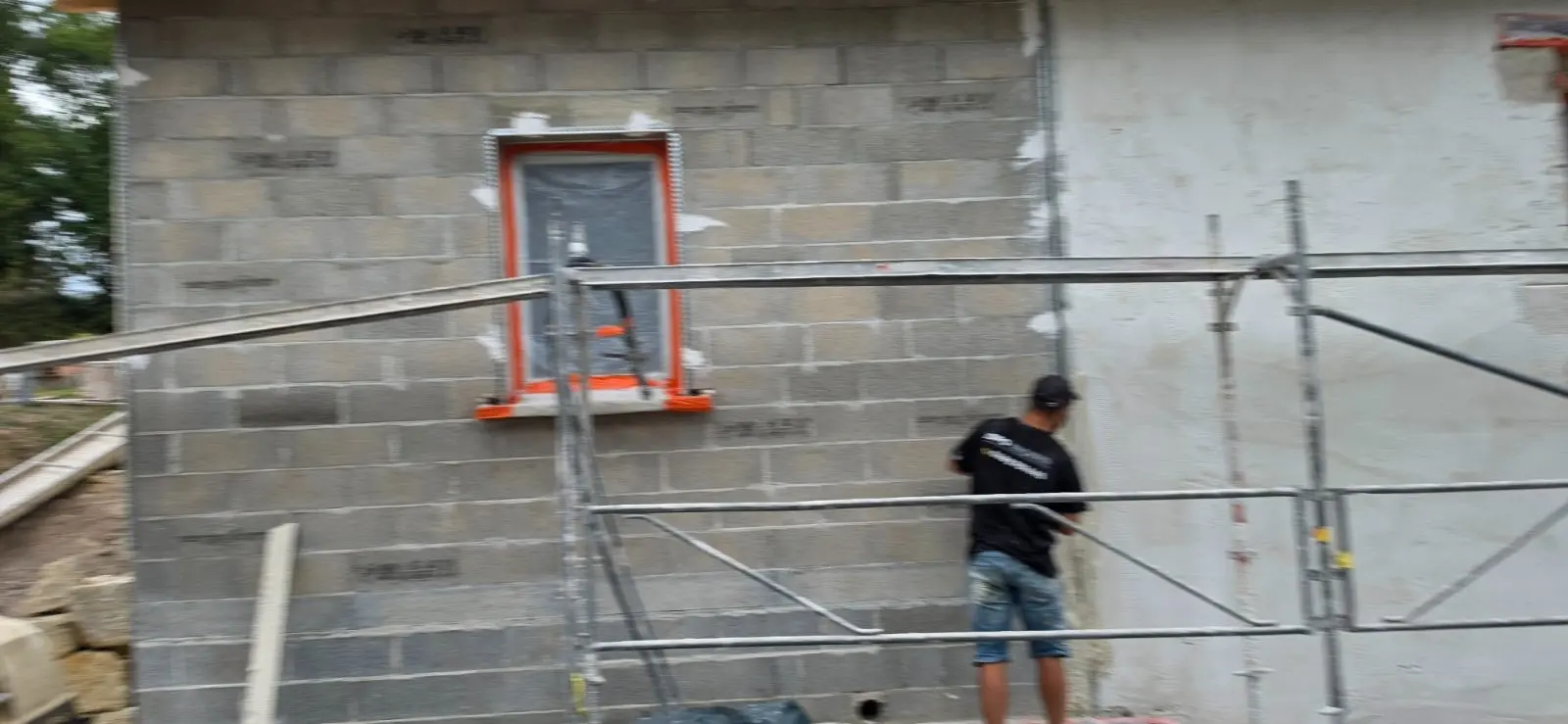 Mur en parpaing de la partie neuve avant enduit de finition monocouche à Lussac