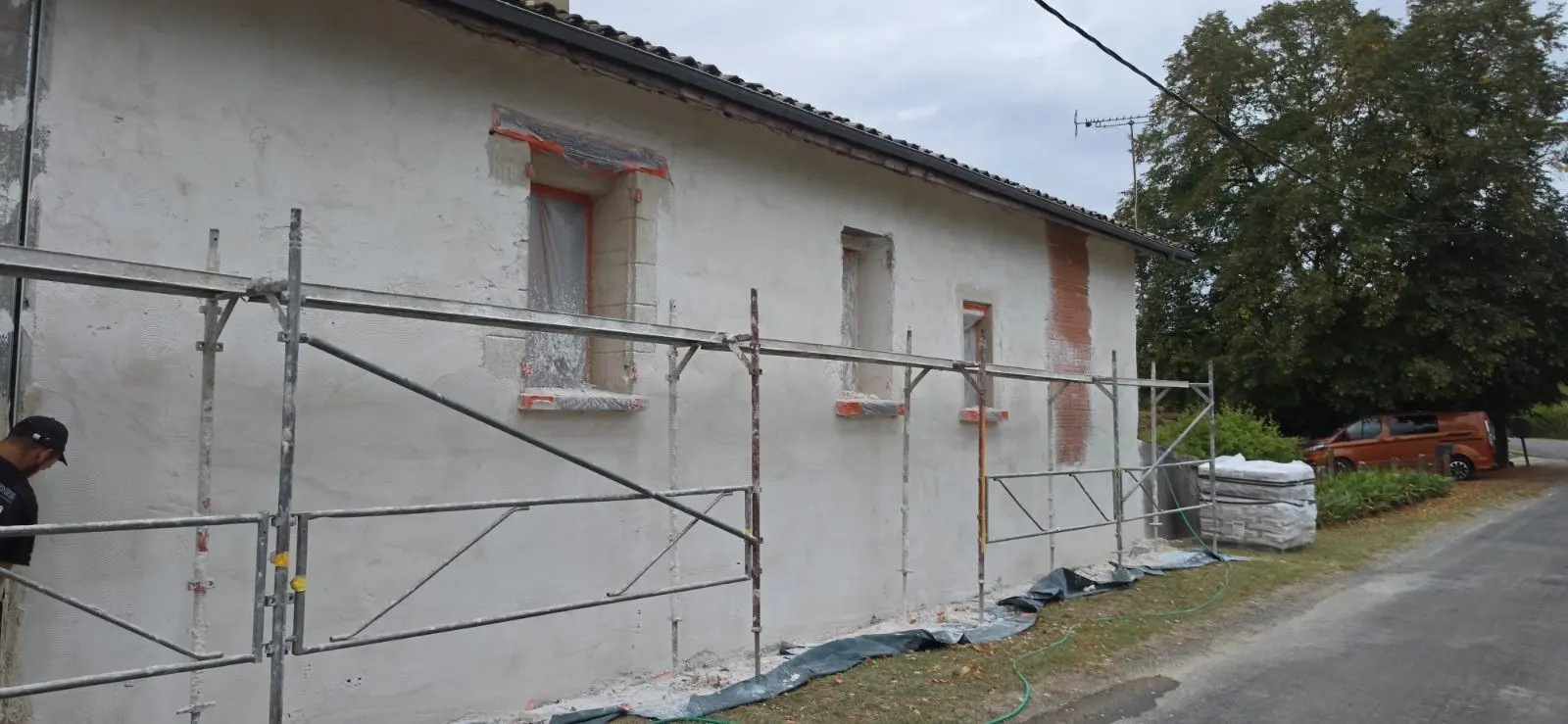 Échafaudage et sous-couche à la chaux en cours sur la partie ancienne d'une maison à Lussac