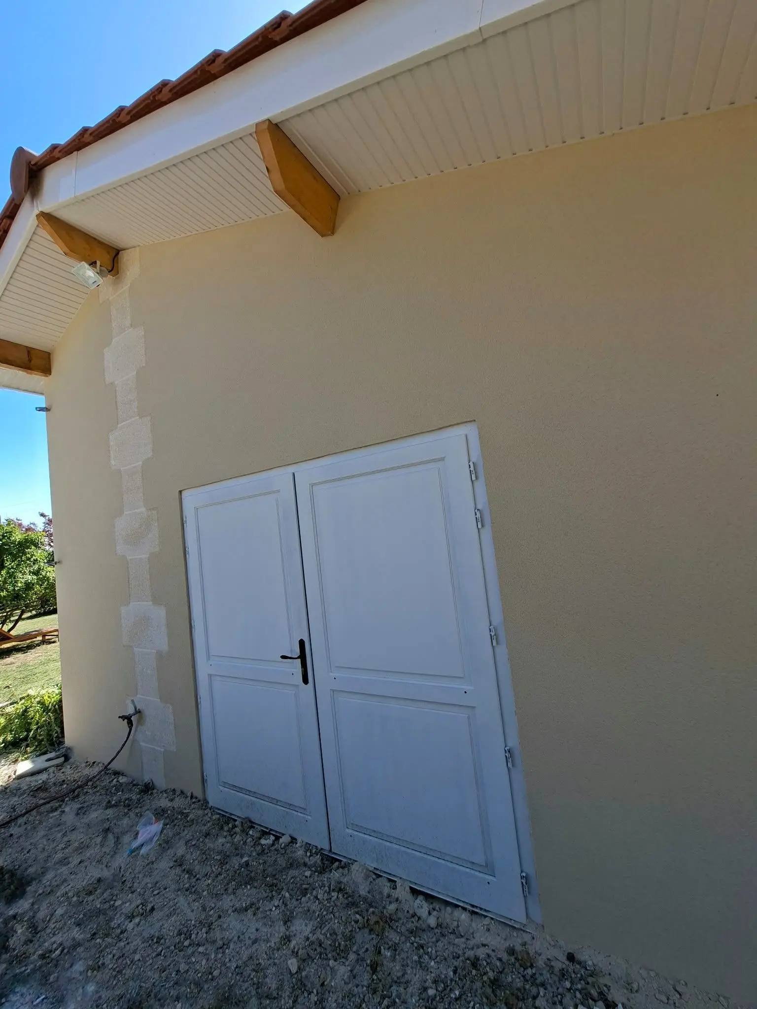 Façade enduite ton pierre gratté fin avec parement pierre sur une maison ancienne à Fronsac