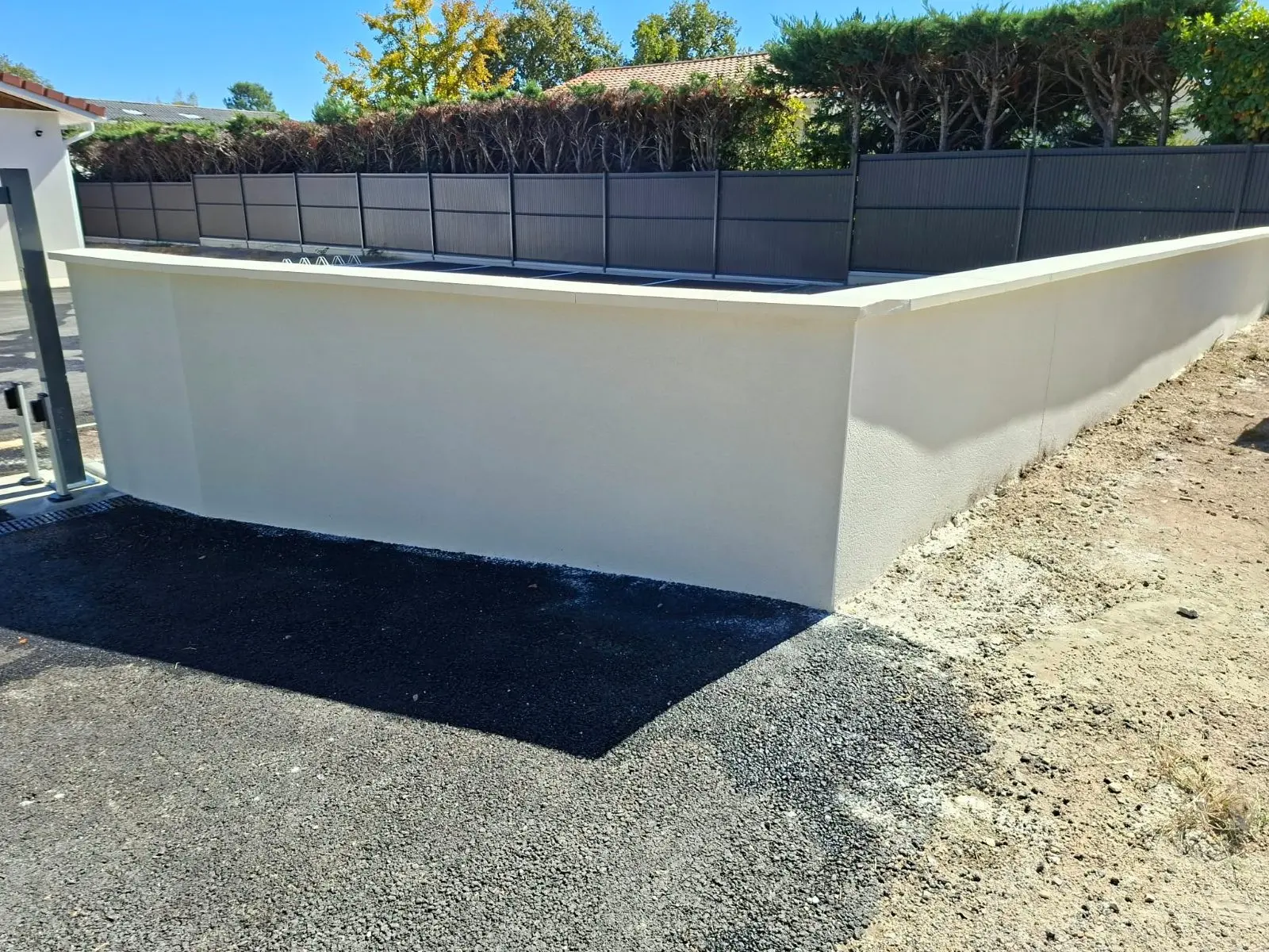 Mur de clôture enduit blanc gratté fin sur une maison neuve à Cestas