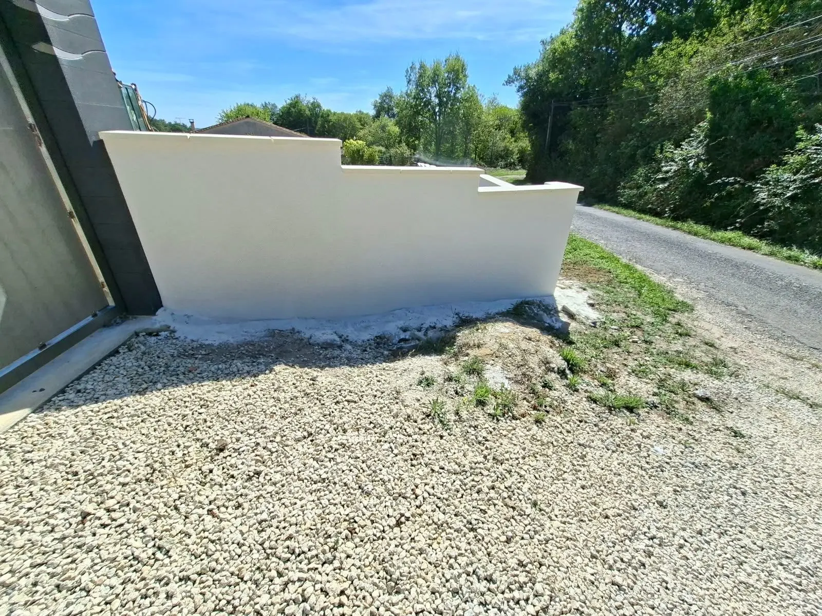 Angle d'un mur de clôture enduit finition gratté fin à Lagorce