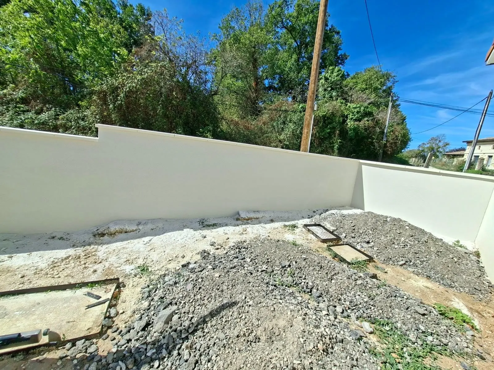 Pilier et mur de clôture enduits d'une maison neuve à Lagorce