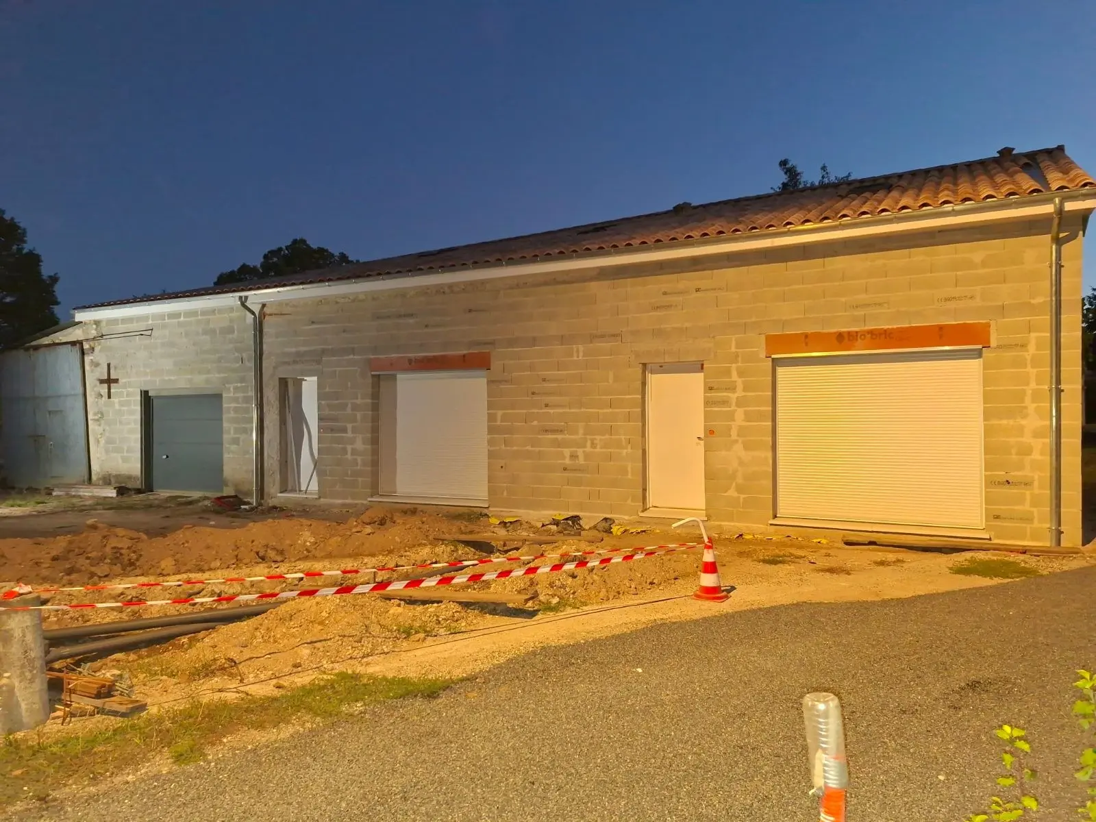 Mur en blocs de parpaing avant enduit sur la partie neuve d'une maison à Montendre