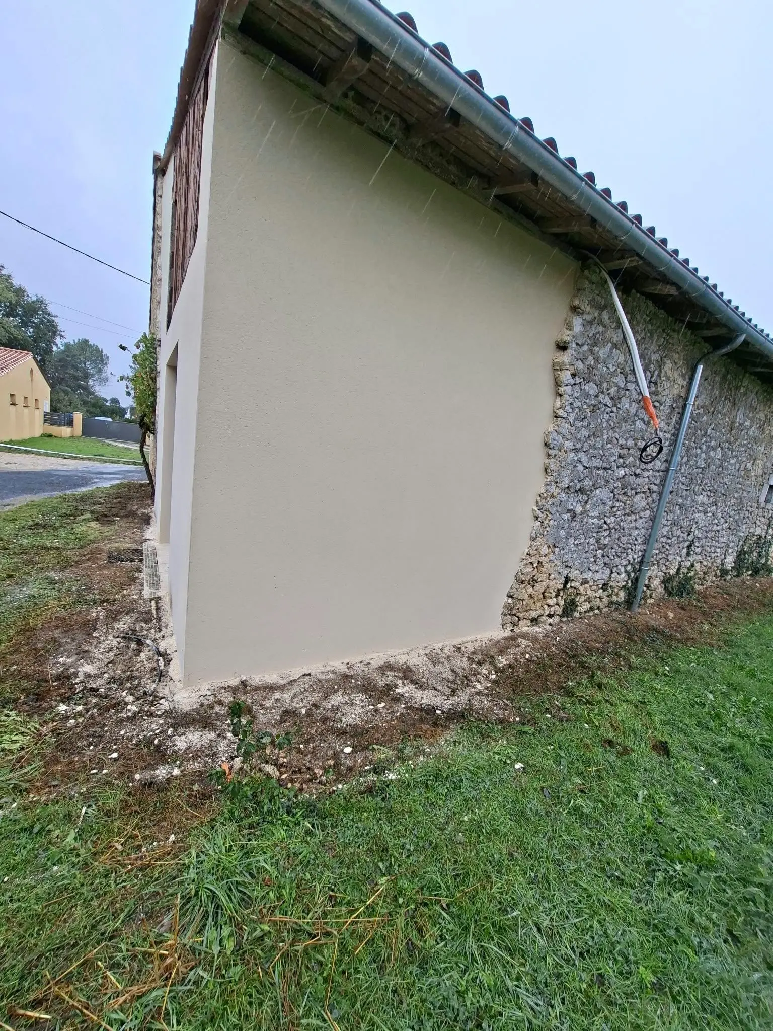 Façade principale enduite ton pierre de la partie neuve d'une maison à Montendre