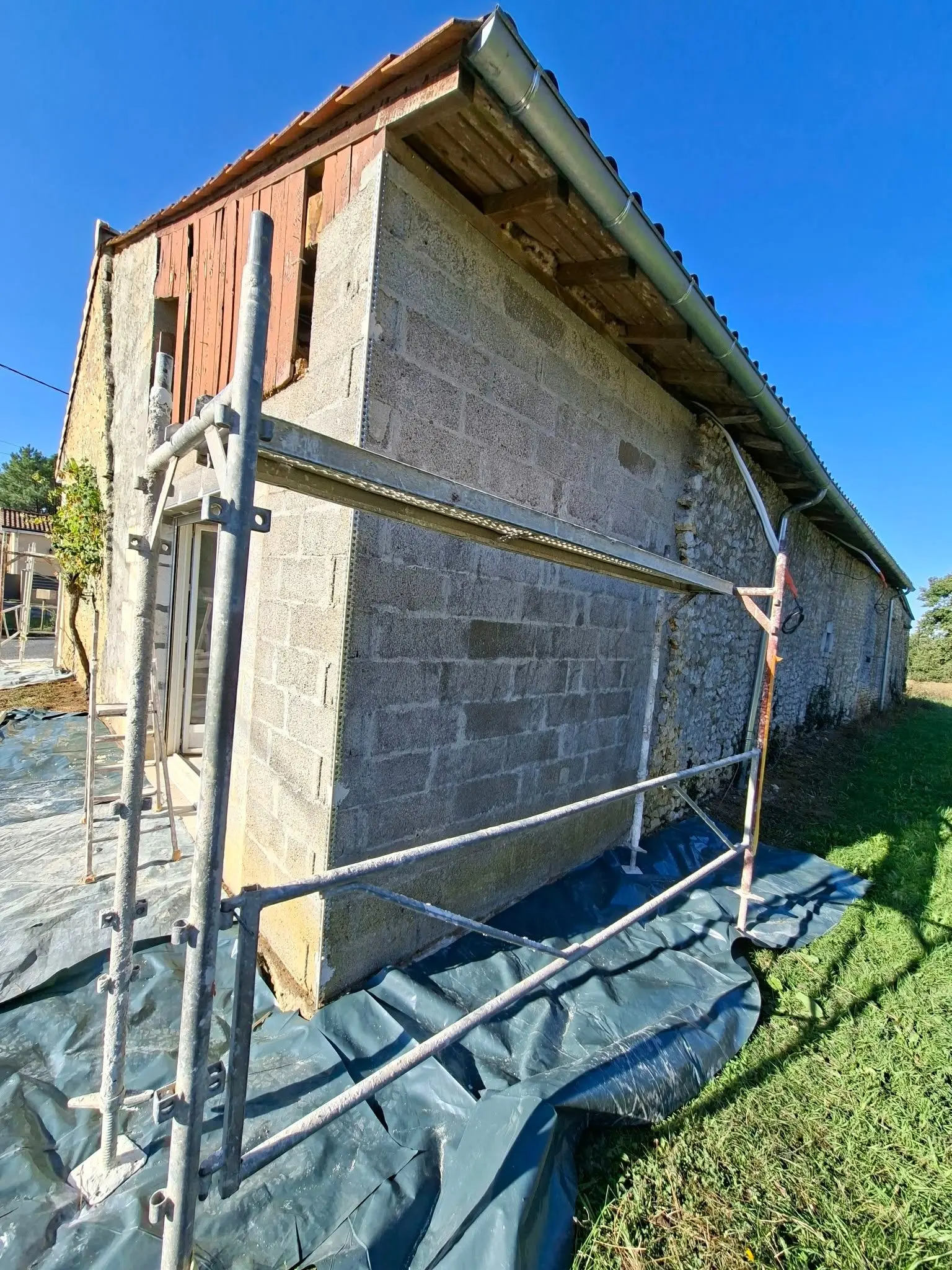 Mur pignon avant application de l'enduit sur la partie neuve d'une maison à Montendre