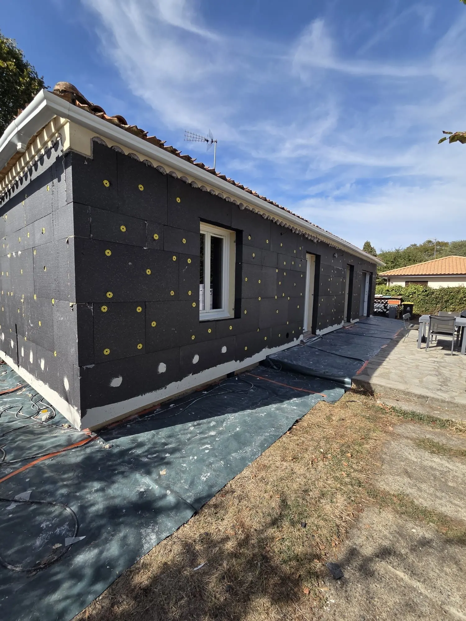 Façade d'une maison ancienne à Coutras avant finition, panneaux isolants ITE posés et fixés